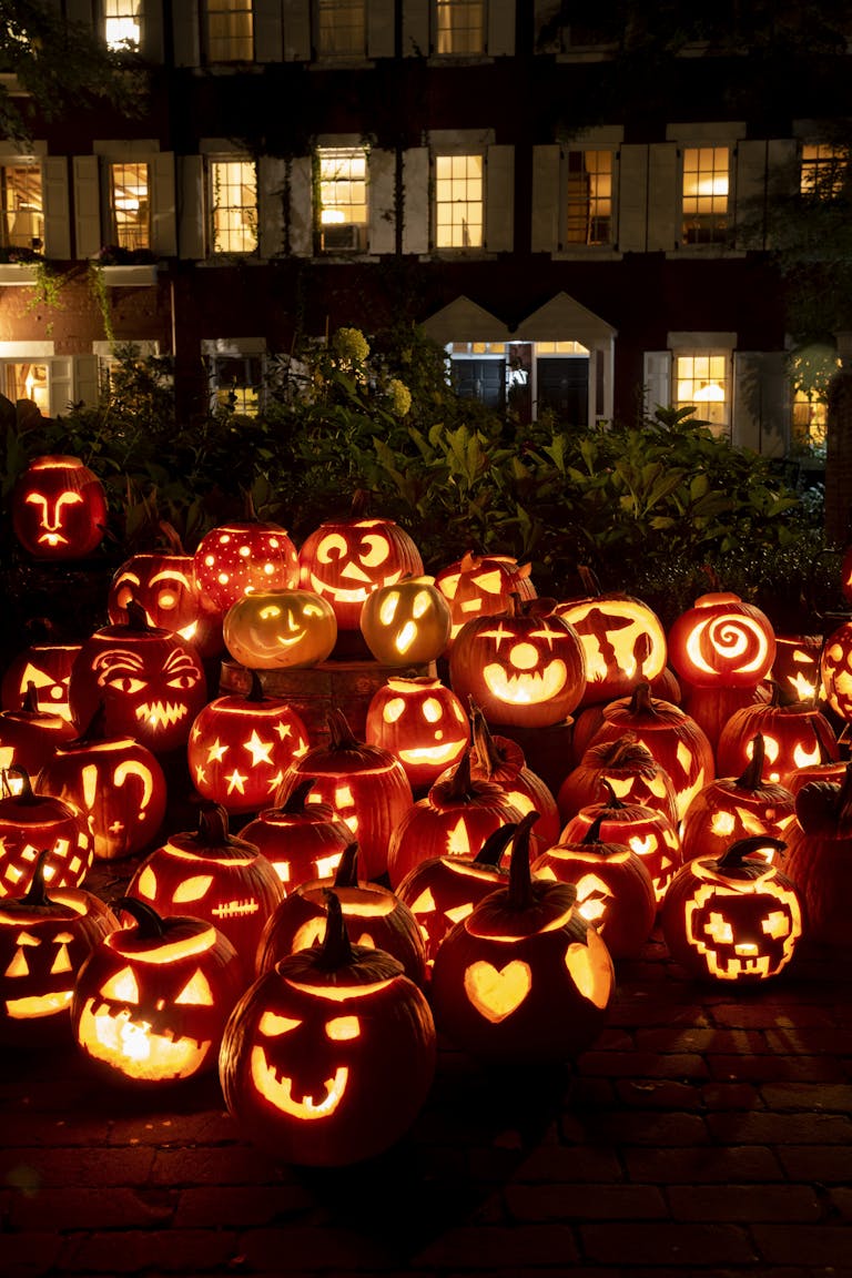 Festive display of illuminated Halloween pumpkins outside a New York building at night.
