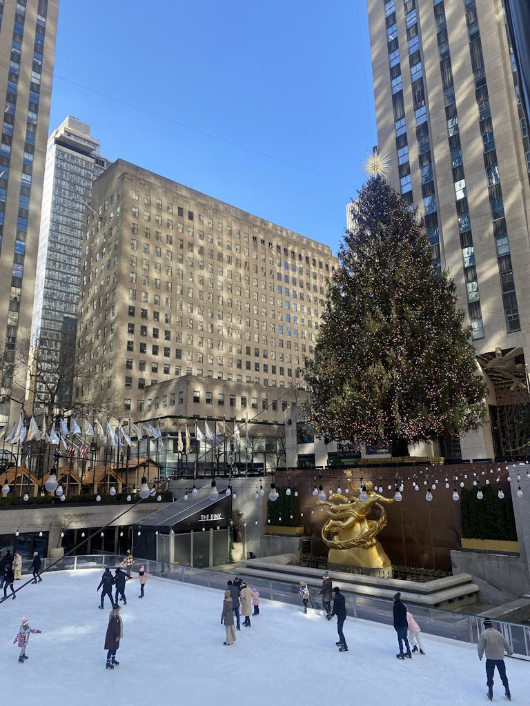 Ice skaters enjoy a winter day at Rockefeller Center with a festive Christmas tree.